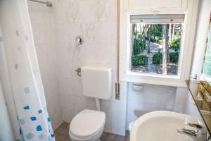 een badkamer met toilet, wastafel en raam bij Spacious first-floor flat near the beach in Eraclea Mare