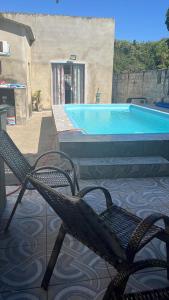 una sedia seduta di fronte alla piscina di casa na praia a Itanhaém