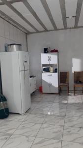 una cucina con un frigorifero bianco e una stufa di casa na praia a Itanhaém