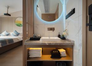 Un baño con lavabo y cama. en 柯凡酒店-近张家界森林公园,打车十分钟,线上英语服务,免费推荐游玩路线,预约门票, en Zhangjiajie