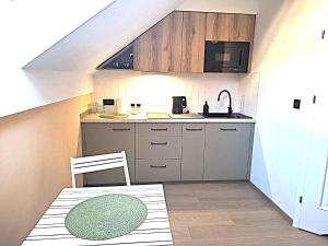 eine kleine Küche mit Tisch und Spüle in der Unterkunft Apartament Ricardo in Krynica-Zdrój + 6 Fotos