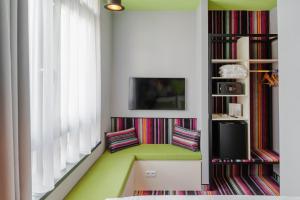 a living room with two chairs and a tv at Mamaison Vibe Hotel Downtown Budapest in Budapest