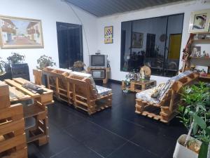 sala de estar con sillas de madera y TV en Hospedaje Granja Agroturística Fruto de los Andes Nemocón, en Nemocón