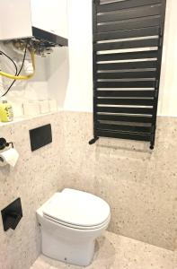 bagno con servizi igienici bianchi e mensola nera. di Apartament Ricardo a Krynica-Zdrój Altre 7 foto