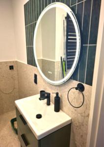 ein Badezimmer mit Waschbecken und Spiegel in der Unterkunft Apartament Ricardo in Krynica-Zdrój