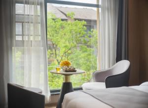 Una habitación con una mesa y sillas y una ventana. en 柯凡酒店-近张家界森林公园,打车十分钟,线上英语服务,免费推荐游玩路线,预约门票, en Zhangjiajie 18 fotos más