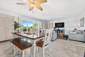 Un comedor con mesa y sillas y una sala de estar. en Beach Oasis - Holiday Special! Beachside Condo with Heated Pool!, en Clearwater Beach