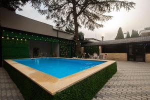 a swimming pool in front of a building at Kinor David Glatt Kosher Hotel in Tbilisi City