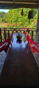 Eine Hängematte auf der Veranda mit Sonnenschirm und Blumen in der Unterkunft Ratanakiri Farmhouse & Trekking in Banlung