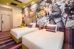 a hotel room with two beds and a mural at Mamaison Vibe Hotel Downtown Budapest in Budapest
