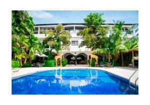 un complejo con piscina frente a un edificio en Hotel La Marsu, en Cap Skirring