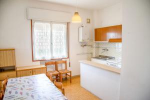 uma cozinha com uma mesa e uma sala de jantar em Two bedroom flat close to the beach in Eraclea em Eraclea Mare