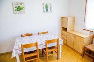 uma mesa de jantar com 4 cadeiras e um armário em Two bedroom flat close to the beach in Eraclea em Eraclea Mare mais 19 fotografias