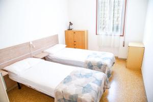 um quarto de hospital com duas camas e uma janela em Two bedroom flat close to the beach in Eraclea em Eraclea Mare