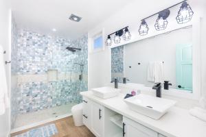 a white bathroom with two sinks and a shower at Beach, Diving & Relaxation at Your Doorstep! in Roatan
