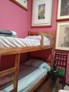 two bunk beds in a room with pink walls at Mini Hostel Fine Art in Vitória da Conquista +33 photos