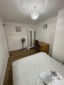 a bedroom with a bed and a desk and a clock at Double Room - Central Dartford - Free Parking in Dartford