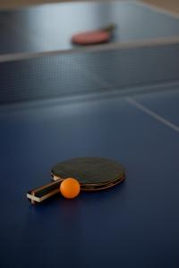 uma raquete de tênis com uma bola laranja sobre uma mesa em The Hundred House by Kisah Stays - Wayanad Colonial Estate Bungalow em Ambalavayal