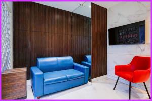 ein Wartezimmer mit zwei blauen Stühlen und einem roten Stuhl in der Unterkunft Hotel Prerna Premium Inn in Bhubaneshwar