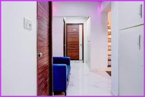 ein Flur mit einem blauen Stuhl und einer Tür in der Unterkunft Hotel Prerna Premium Inn in Bhubaneshwar