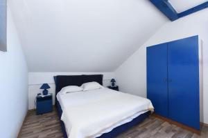 een slaapkamer met een groot bed en een blauwe kast bij Beach Apartment in Bibinje