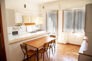 Una cocina con una mesa y sillas de madera. en Central apartment at 250mt from the sea, en Eraclea Mare