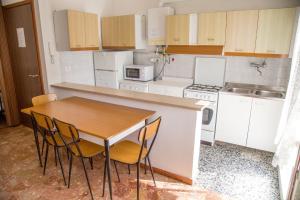 una pequeña cocina con mesa de madera y sillas en Central apartment at 250mt from the sea, en Eraclea Mare 18 fotos más