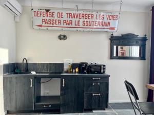 ナントにあるExclusivité - La Maison à Vapeurのシンクと壁に看板のあるキッチン +4枚の写真