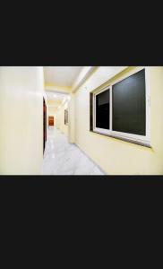 een gang met een groot raam in een muur bij Hotel PANCHSHIL in Patna