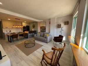 a living room and kitchen with a couch and chairs at Apartamento los Remos VUT-3207AS in Llanes