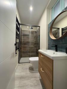 ein Badezimmer mit Toilette, Waschbecken und Spiegel in der Unterkunft Apartamento los Remos VUT-3207AS in Llanes