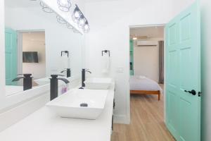 um banheiro com duas pias e um espelho grande em West End's Famous Comfy Sloth em Roatan mais 26 fotografias