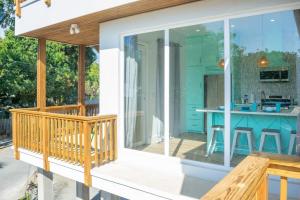uma varanda telada com vista para a cozinha e para a casa em West End's Famous Comfy Sloth em Roatan