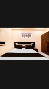 een slaapkamer met een groot bed en twee foto's aan de muur bij Hotel PANCHSHIL in Patna