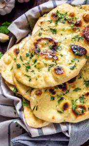 Twee pizza's met kaas en kruiden op een bord. bij Hotel PANCHSHIL in Patna