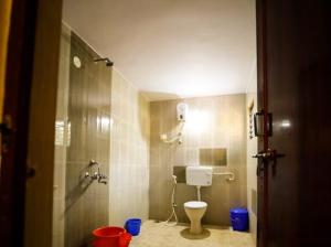 a bathroom with a shower and a toilet in it at Adventure Inn Dandeli in Kurandi +43 photos