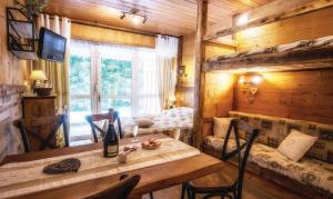 een eetkamer met een tafel en een raam bij Les Champis in La Bresse +1 foto