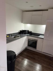 a small kitchen with white cabinets and a sink at 505 City Centre Stylish Double Apartment in Birmingham