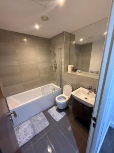 a bathroom with a tub and a toilet and a sink at 505 City Centre Stylish Double Apartment in Birmingham