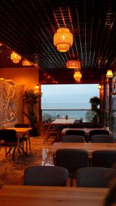 ein Restaurant mit Tischen und Stühlen und einem großen Fenster in der Unterkunft Tüm Palace Otel in Bandırma