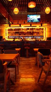 ein Restaurant mit Holztischen und eine Bar mit Fernseher in der Unterkunft Tüm Palace Otel in Bandırma