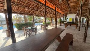 a large wooden table in a patio with a pool at NLC locações BonsVentos in Barreirinhas