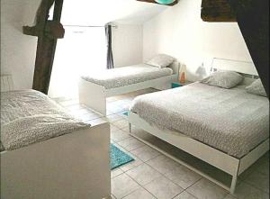 ein Schlafzimmer mit 2 Betten und einem Kreuz an der Wand in der Unterkunft Gîte proche du Futuroscope in Jaunay-Clan