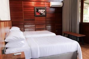 a hotel room with two beds and a picture on the wall at Voyage Retreat Pulau Pangkor 归航楼 in Pasir Bogak