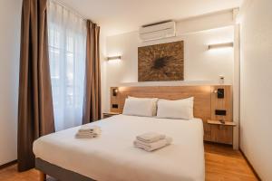a hotel room with a bed with two towels on it at Residhotel Mulhouse Centre in Mulhouse