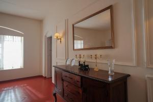 um quarto com um espelho e uma cômoda de madeira em The Hundred House by Kisah Stays - Wayanad Colonial Estate Bungalow em Ambalavayal mais 107 fotografias