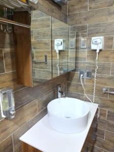 Un baño con un lavabo blanco y un espejo. en Hotel Boutique Frutos del bosque de Zacatlan, en Jicolapa