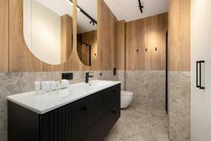 a bathroom with a sink and a toilet and a mirror at Unique Studio with Parking Space and Swimming Pool by Noclegi Renters in Pobierowo