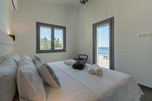 ein Schlafzimmer mit einem großen weißen Bett mit Handtüchern darauf in der Unterkunft Areti-Elena Oxomeria in Katsimátika + 43 Fotos