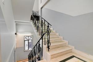 a staircase in a home with white walls at FabHotel Rajdanga Retreat in Kolkata